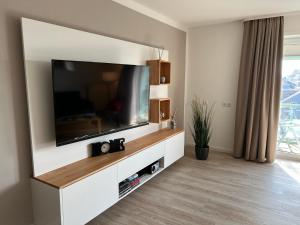 uma sala de estar com uma grande televisão de ecrã plano em Steiner Strandappartements Appartement 307 Süd- Landseite em Stein