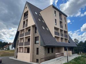 um edifício com um telhado preto em cima em Sova apartman em Divčibare