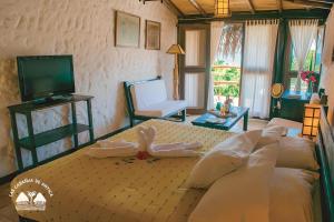 1 dormitorio con 1 cama grande y TV en Las Cabañas de Antica, en Vichayito