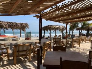 una spiaggia con tavoli e sedie e l'oceano di Las Cabañas de Antica a Vichayito