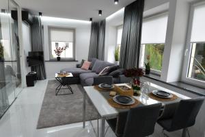 a living room with a couch and a table at Grey 5 Zgorzelec - Görlitz in Zgorzelec