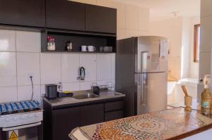 a kitchen with a stainless steel refrigerator and a sink at apartamento vista mar 2 quartos estacionamento gratis Netflix e self check in in Maceió
