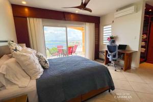 Schlafzimmer mit einem Bett und Meerblick in der Unterkunft Villa Sea Forever @ Pelican Key - Paradise Awaits! in Simpson Bay