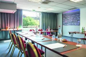 a conference room with a long table and chairs at Kyriad Paris Saint Ouen in Saint-Ouen