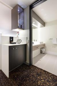 a bathroom with a sink, toilet, and bathtub at Calamvale Hotel Suites and Conference Centre in Brisbane