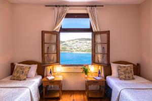 two beds in a room with a large window at Villa OZ in Kalkan