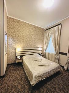 ein Schlafzimmer mit einem großen Bett und einem Fenster in der Unterkunft Classic Hotel in Kharkov