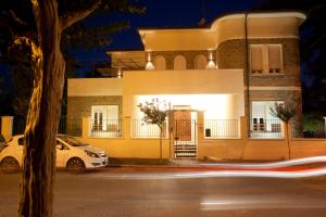 um carro branco estacionado em frente a uma casa à noite em B&B Casa Dei Grilli em Longiano