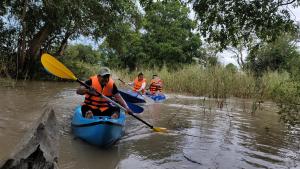 three people in kayaks on a river at Kbon Homestay Experience in Siem Reap