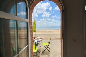 een open deur naar een patio met uitzicht op het strand bij Superbe appartement les pieds dans l'eau ! in La Tranche-sur-Mer