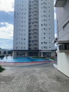 a swimming pool in front of a tall building at Condo in Avida tower IT park , Lahug Cebu city, Fully furnished in Cebu City