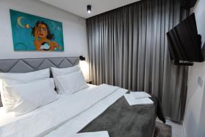 a bedroom with a large bed with a painting on the wall at Grey 5 Zgorzelec - Görlitz in Zgorzelec +25 photos