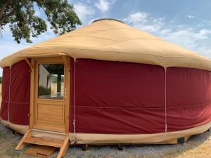 a red and brown yurt with a wooden door at Yourte proche canal in Saffré