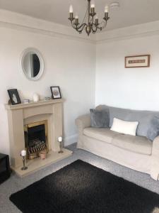 a living room with a couch and a fireplace at Homely property close to Princess Royal hospital and Apley Wood in Wellington