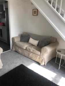 a couch in a living room under a staircase at Homely property close to Princess Royal hospital and Apley Wood in Wellington