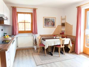 a kitchen with a table and chairs in a room at Apartment house Niedermunthof, Funes in Villnoss