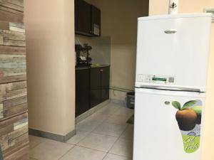 a kitchen with a white refrigerator with an apple on it at Backpacker's Bed - Central Bus Terminal in Abu Dhabi