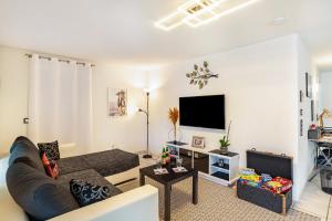 ein Wohnzimmer mit einem Sofa und einem TV in der Unterkunft Bei s' Herrs in Rheinmunster