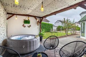 a hot tub on a patio with two chairs at Bei s' Herrs in Rheinmunster