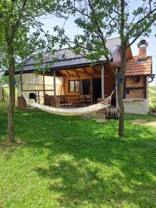 ein Haus mit einer Hängematte davor in der Unterkunft Vikendica za odmor in Banja Luka
