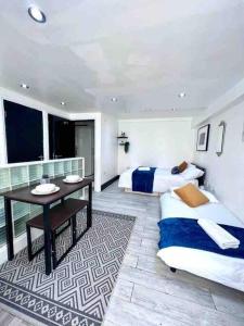 1 dormitorio con 2 camas, mesa y escritorio en Studio Apartment in London en Londres