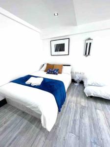 1 dormitorio con 2 camas en una habitación blanca en Studio Apartment in London en Londres