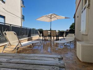 a patio with a table and chairs and an umbrella at Susy's Home Appartamento in centro in Corchiano
