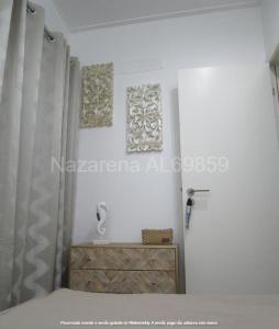 een slaapkamer met 2 schilderijen aan de muur en een bed bij Nazarena in Nazaré