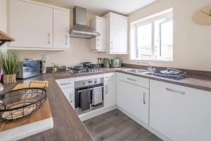 a kitchen with white cabinets and a counter top at 2 bed house near Ricoh Arena, 2xparking, wifi in Longford