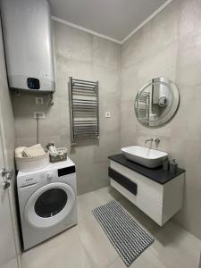 ein Badezimmer mit einer Waschmaschine und einem Waschbecken in der Unterkunft Aleksandar in Subotica