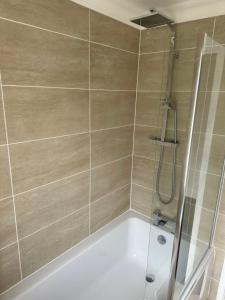 a bathroom with a shower with a bath tub at 1 bedroom modern house near hospital with parking in Southampton