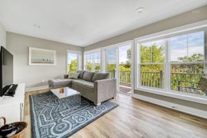 a living room with a couch and large windows at Hot Tub - Saugatuck/Douglas - Three Bedroom - Sleeps 8 in Douglas