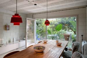 a dining room with a wooden table and a large window at Fabrica No Jardim in Porto