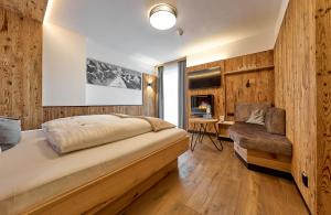 a bedroom with a bed and a desk and a chair at Hotel Gamsleiten in Obertauern