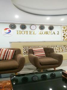 Zimmer mit 2 Stühlen und einem Hotelkorea-Schild in der Unterkunft GRAD Korea Hotel 2 in Làng Thành