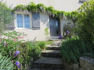 a house with a blue door and some flowers at Chez Pierre et Caroline in Les Herbiers