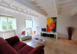 una sala de estar con un sofá rojo y una pintura en Acacia Firenze - Magnolia, en Florencia
