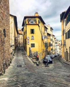 un callejón con un edificio amarillo en una calle de la ciudad en Acacia Firenze - Magnolia, en Florencia