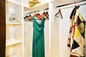 un armario con un vestido verde en un estante en Acacia Firenze - Magnolia, en Florencia