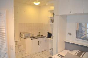 a small kitchen with white cabinets and a sink at AV No.1 in Düsseldorf