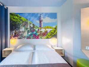 1 dormitorio con 1 cama con una foto de un faro en B&B Hotel Neu-Ulm, en Neu-Ulm