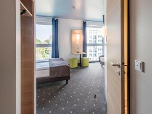 um quarto de hotel com uma cama e uma janela em B&B Hotel Neu-Ulm em Neu-Ulm