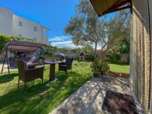 un cortile con sedie, tavolo e ombrellone di Gardenia Two a Novigrad Istria Altre 9 foto