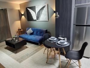ein Wohnzimmer mit einem blauen Sofa und einem Tisch in der Unterkunft Chic y Hermoso Apartamento Amoblado y Equipado Los Mangos 3 Valencia-Venezuela in Valencia