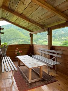 Household Babovic - Old house Miljan's valley في Andrijevica: شرفة خشبية مع مقعد وطاولة