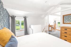 a bedroom with a bed and a desk and a refrigerator at The Black Dog Apartment in Dalton in Furness