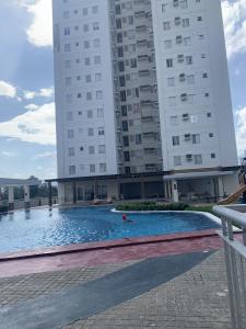 a swimming pool in front of a tall building at Condo in Avida tower IT park , Lahug Cebu city, Fully furnished in Cebu City