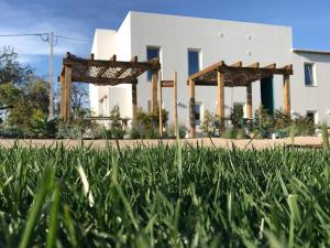 a field of grass in front of a white building at Tavira-Quinta da Janela Azul in Tavira