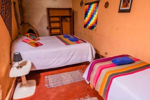 a bedroom with two beds and a table and a ladder at Casa Voyage Hostel in San Pedro de Atacama