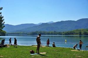 a group of people standing on the grass near a lake at BEAUTIFUL ROOM RIVER in Anglés